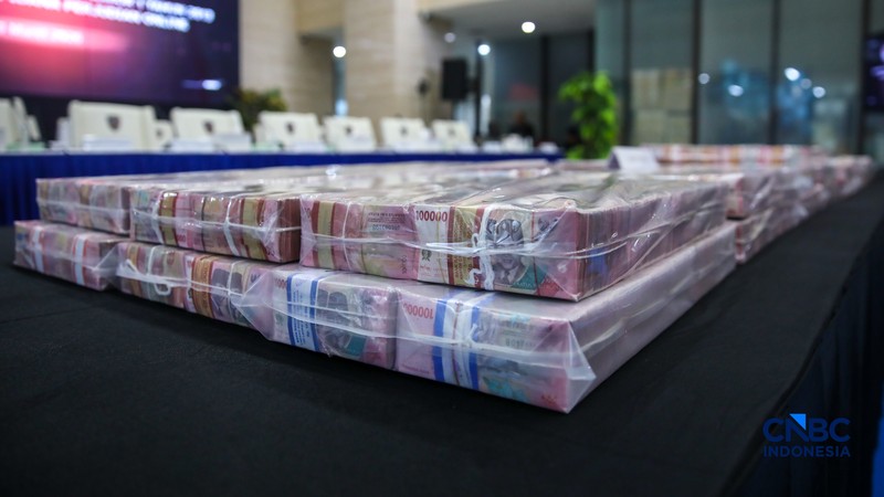 Petugas mentar umpukan uang saat Penyerahan Tanggung Jawab Dan Eksekusi Atas Harta Kekayaan Hasil Tindak Pidana Pencucian Uang Yang Berasal Dari Judi Online di Gedung Awaloedin Djamin Bareskrim Polri, Jakarta, Kamis (5/3/2026). (CNBC Indonesia/Faisal Rahman)