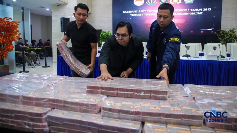 Petugas mentar umpukan uang saat Penyerahan Tanggung Jawab Dan Eksekusi Atas Harta Kekayaan Hasil Tindak Pidana Pencucian Uang Yang Berasal Dari Judi Online di Gedung Awaloedin Djamin Bareskrim Polri, Jakarta, Kamis (5/3/2026). (CNBC Indonesia/Faisal Rahman)