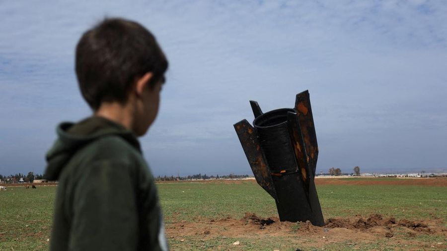 Seorang anak berdiri di samping sebuah rudal setelah jatuh di dekat Bandara Internasional Qamishli, di tengah konflik AS-Israel dengan Iran, di Qamishli, Suriah, 4 Maret 2026. (REUTERS/Orhan Qereman)