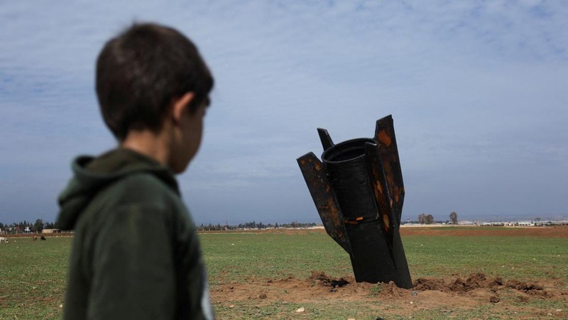 Seorang anak berdiri di samping sebuah rudal setelah jatuh di dekat Bandara Internasional Qamishli, di tengah konflik AS-Israel dengan Iran, di Qamishli, Suriah, 4 Maret 2026. (REUTERS/Orhan Qereman)