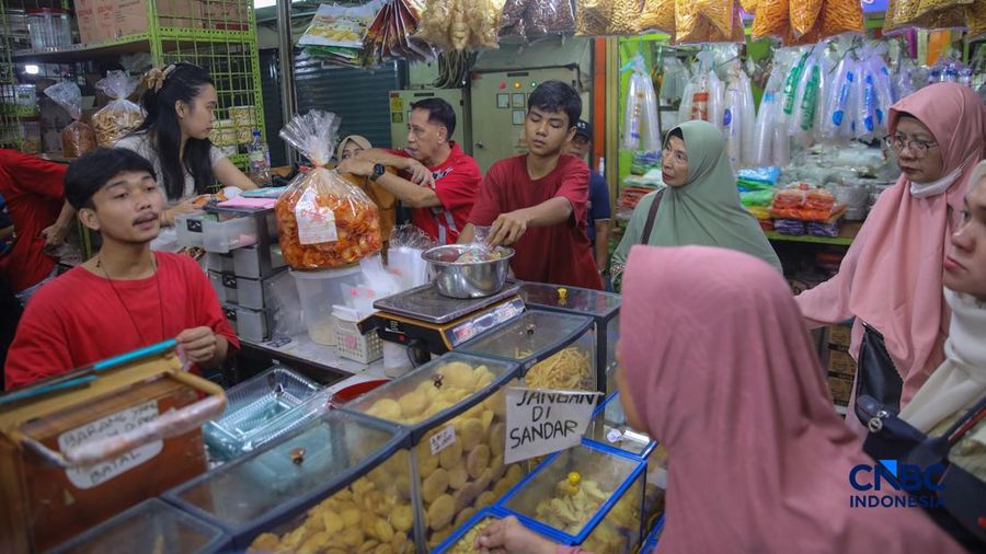 Pedagang kue kering dan kue lebaran melayani pembeli yang dijual di Pasar Jatinegara, Jakarta, Senin (9/3/2026). (CNBC Indonesia/Faisal Rahman)