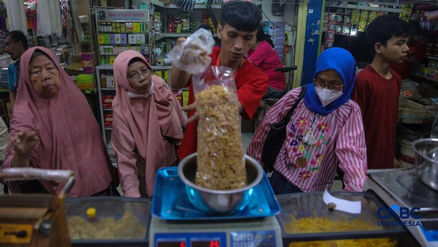 Pedagang kue kering dan kue lebaran melayani pembeli yang dijual di Pasar Jatinegara, Jakarta, Senin (9/3/2026). (CNBC Indonesia/Faisal Rahman)