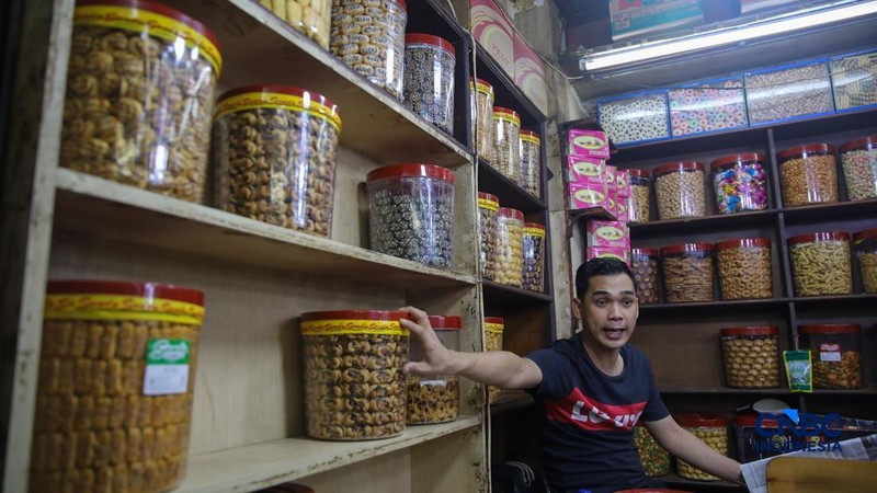 Pedagang kue kering dan kue lebaran melayani pembeli yang dijual di Pasar Jatinegara, Jakarta, Senin (9/3/2026). (CNBC Indonesia/Faisal Rahman)