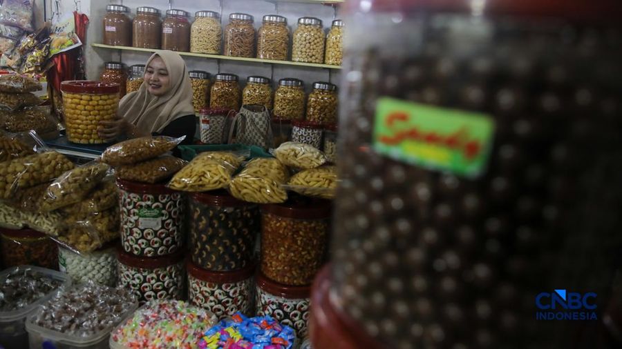 Pedagang kue kering dan kue lebaran melayani pembeli yang dijual di Pasar Jatinegara, Jakarta, Senin (9/3/2026). (CNBC Indonesia/Faisal Rahman)