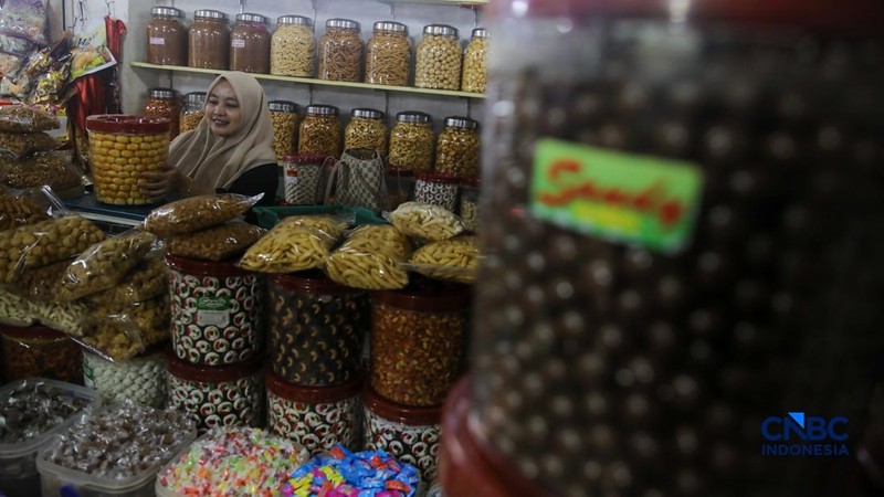 Pedagang kue kering dan kue lebaran melayani pembeli yang dijual di Pasar Jatinegara, Jakarta, Senin (9/3/2026). (CNBC Indonesia/Faisal Rahman)