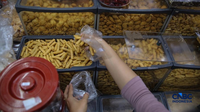Pedagang kue kering dan kue lebaran melayani pembeli yang dijual di Pasar Jatinegara, Jakarta, Senin (9/3/2026). (CNBC Indonesia/Faisal Rahman)