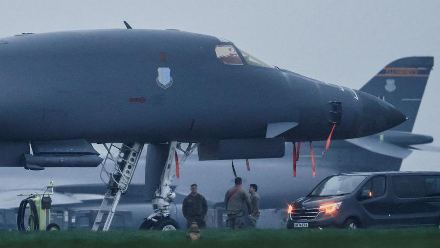 Sebuah pesawat Boeing C-17A Globemaster milik Angkatan Udara Amerika Serikat (USAF) mendarat di belakang pesawat pembom B-1B USAF yang diparkir di samping landasan pacu di pangkalan udara RAF Fairford, yang digunakan oleh USAF, di tengah konflik AS-Israel dengan Iran, di Fairford, Inggris, 8 Maret 2026. (REUTERS/Toby Melville)