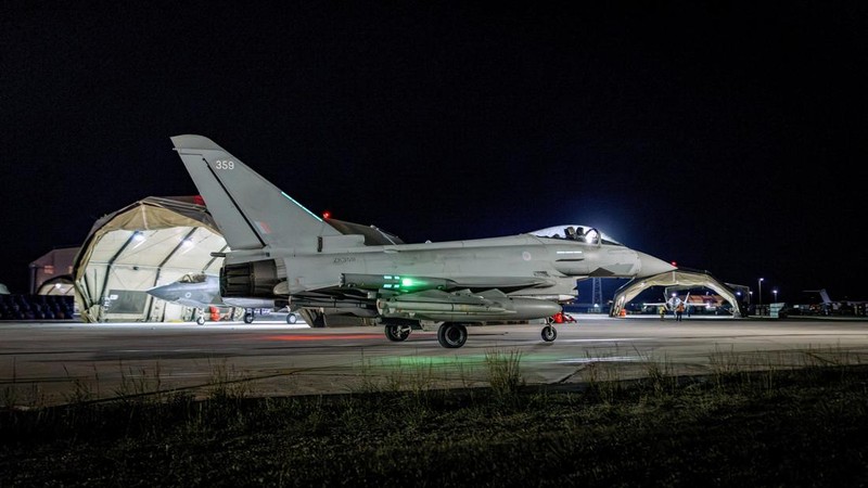 Sebuah pesawat Boeing C-17A Globemaster milik Angkatan Udara Amerika Serikat (USAF) mendarat di belakang pesawat pembom B-1B USAF yang diparkir di samping landasan pacu di pangkalan udara RAF Fairford, yang digunakan oleh USAF, di tengah konflik AS-Israel dengan Iran, di Fairford, Inggris, 8 Maret 2026. (REUTERS/Toby Melville)