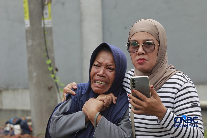 Sejumlah petugas mengevakuasi jenazah dengan kantung saat melakukan pencarian korban longsor gunungan sampah di Tempat Pengolahan Sampah Terpadu (TPST) Bantargebang, Bekasi, Jawa Barat, Senin (9/3/2026). (CNBC Indonesia/Muhammad Sabki)