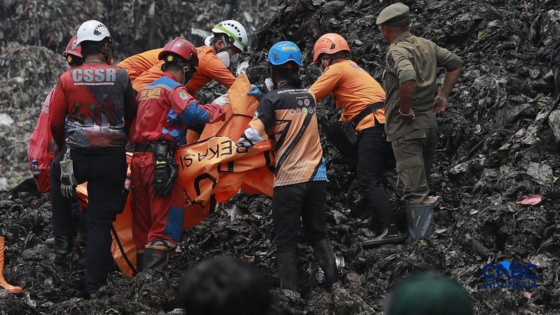 Sejumlah petugas mengevakuasi jenazah dengan kantung saat melakukan pencarian korban longsor gunungan sampah di Tempat Pengolahan Sampah Terpadu (TPST) Bantargebang, Bekasi, Jawa Barat, Senin (9/3/2026). (CNBC Indonesia/Muhammad Sabki)