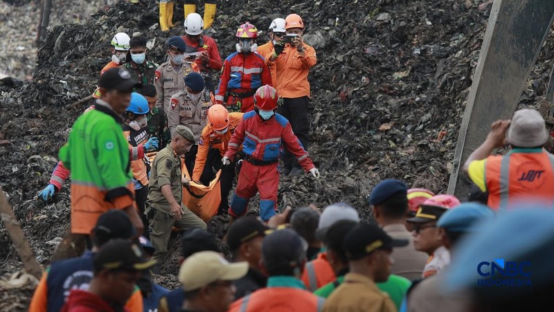 Sejumlah petugas mengevakuasi jenazah dengan kantung saat melakukan pencarian korban longsor gunungan sampah di Tempat Pengolahan Sampah Terpadu (TPST) Bantargebang, Bekasi, Jawa Barat, Senin (9/3/2026). (CNBC Indonesia/Muhammad Sabki)