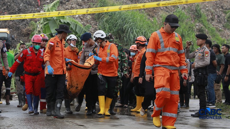 Sejumlah petugas mengevakuasi jenazah dengan kantung saat melakukan pencarian korban longsor gunungan sampah di Tempat Pengolahan Sampah Terpadu (TPST) Bantargebang, Bekasi, Jawa Barat, Senin (9/3/2026). (CNBC Indonesia/Muhammad Sabki)