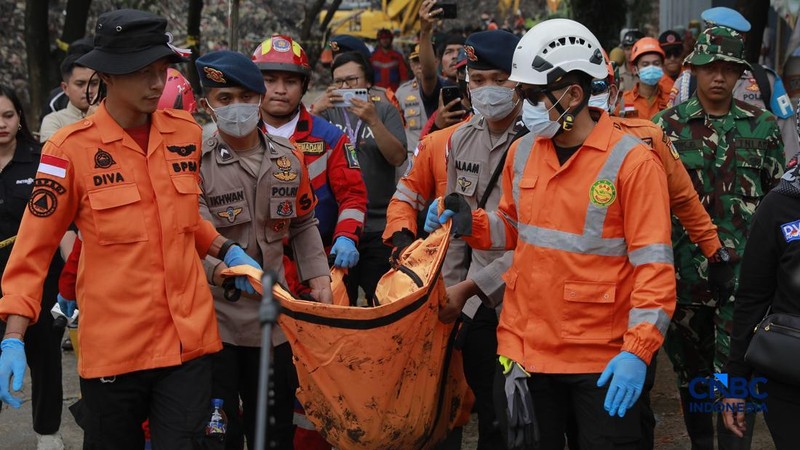 Sejumlah petugas mengevakuasi jenazah dengan kantung saat melakukan pencarian korban longsor gunungan sampah di Tempat Pengolahan Sampah Terpadu (TPST) Bantargebang, Bekasi, Jawa Barat, Senin (9/3/2026). (CNBC Indonesia/Muhammad Sabki)