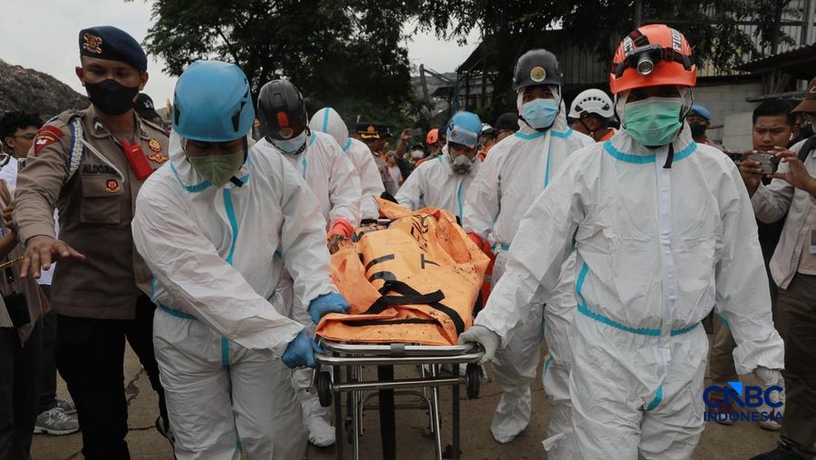 Sejumlah petugas mengevakuasi jenazah dengan kantung saat melakukan pencarian korban longsor gunungan sampah di Tempat Pengolahan Sampah Terpadu (TPST) Bantargebang, Bekasi, Jawa Barat, Senin (9/3/2026). (CNBC Indonesia/Muhammad Sabki)