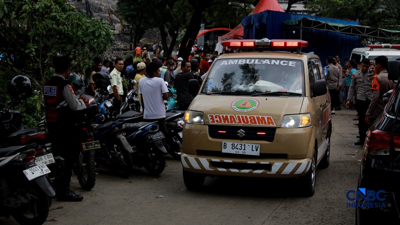 Sejumlah petugas mengevakuasi jenazah dengan kantung saat melakukan pencarian korban longsor gunungan sampah di Tempat Pengolahan Sampah Terpadu (TPST) Bantargebang, Bekasi, Jawa Barat, Senin (9/3/2026). (CNBC Indonesia/Muhammad Sabki)