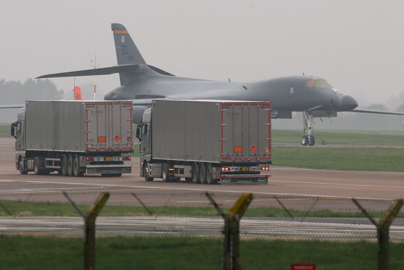 Sebuah pesawat Boeing C-17A Globemaster milik Angkatan Udara Amerika Serikat (USAF) mendarat di belakang pesawat pembom B-1B USAF yang diparkir di samping landasan pacu di pangkalan udara RAF Fairford, yang digunakan oleh USAF, di tengah konflik AS-Israel dengan Iran, di Fairford, Inggris, 8 Maret 2026. (REUTERS/Toby Melville)