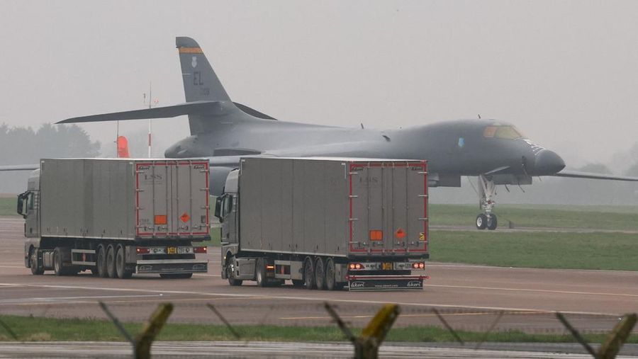 Sebuah pesawat Boeing C-17A Globemaster milik Angkatan Udara Amerika Serikat (USAF) mendarat di belakang pesawat pembom B-1B USAF yang diparkir di samping landasan pacu di pangkalan udara RAF Fairford, yang digunakan oleh USAF, di tengah konflik AS-Israel dengan Iran, di Fairford, Inggris, 8 Maret 2026. (REUTERS/Toby Melville)