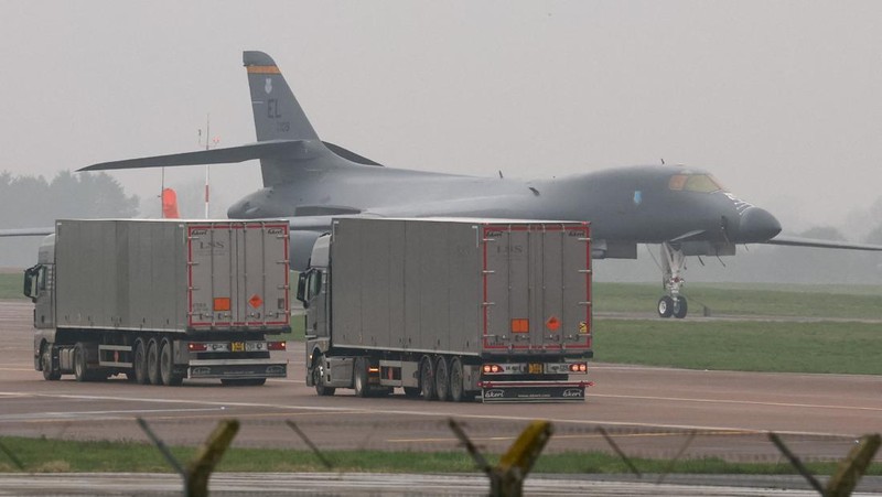 Sebuah pesawat Boeing C-17A Globemaster milik Angkatan Udara Amerika Serikat (USAF) mendarat di belakang pesawat pembom B-1B USAF yang diparkir di samping landasan pacu di pangkalan udara RAF Fairford, yang digunakan oleh USAF, di tengah konflik AS-Israel dengan Iran, di Fairford, Inggris, 8 Maret 2026. (REUTERS/Toby Melville)