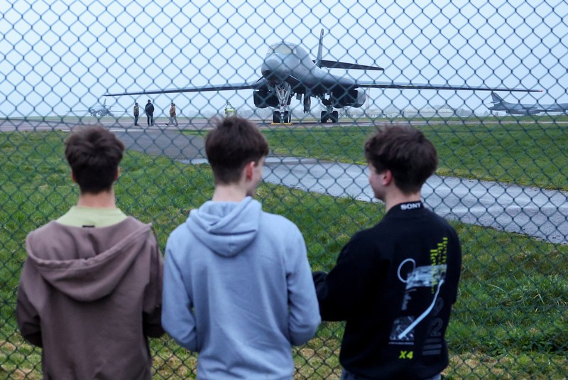 Sebuah pesawat Boeing C-17A Globemaster milik Angkatan Udara Amerika Serikat (USAF) mendarat di belakang pesawat pembom B-1B USAF yang diparkir di samping landasan pacu di pangkalan udara RAF Fairford, yang digunakan oleh USAF, di tengah konflik AS-Israel dengan Iran, di Fairford, Inggris, 8 Maret 2026. (REUTERS/Toby Melville)