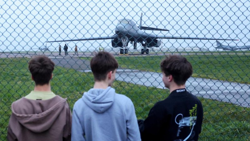 Sebuah pesawat Boeing C-17A Globemaster milik Angkatan Udara Amerika Serikat (USAF) mendarat di belakang pesawat pembom B-1B USAF yang diparkir di samping landasan pacu di pangkalan udara RAF Fairford, yang digunakan oleh USAF, di tengah konflik AS-Israel dengan Iran, di Fairford, Inggris, 8 Maret 2026. (REUTERS/Toby Melville)