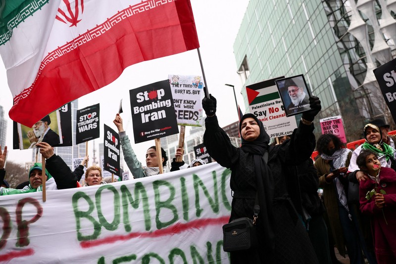 Para wanita membawa plakat selama protes di tengah konflik AS-Israel dengan Iran, di luar kedutaan besar AS di Jakarta, Indonesia, 9 Maret 2026. (REUTERS/Ajeng Dinar Ulfiana)