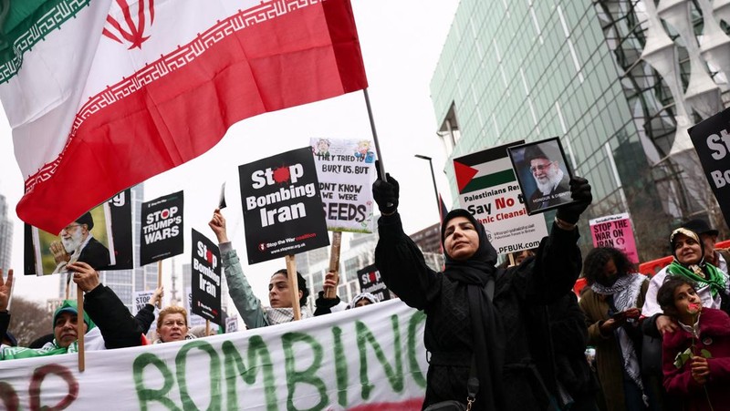 Para wanita membawa plakat selama protes di tengah konflik AS-Israel dengan Iran, di luar kedutaan besar AS di Jakarta, Indonesia, 9 Maret 2026. (REUTERS/Ajeng Dinar Ulfiana)