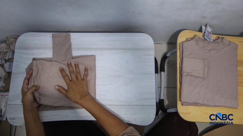 Para pekerja di sebuah toko online Kyazaofficial di Cilincing, Jakarta Utara, sibuk menyiapkan dan mengemas produk fesyen muslim sepekan menjelang Lebaran, Rabu (11/03/2026). (CNBC Indonesia/Faisal Rahman)