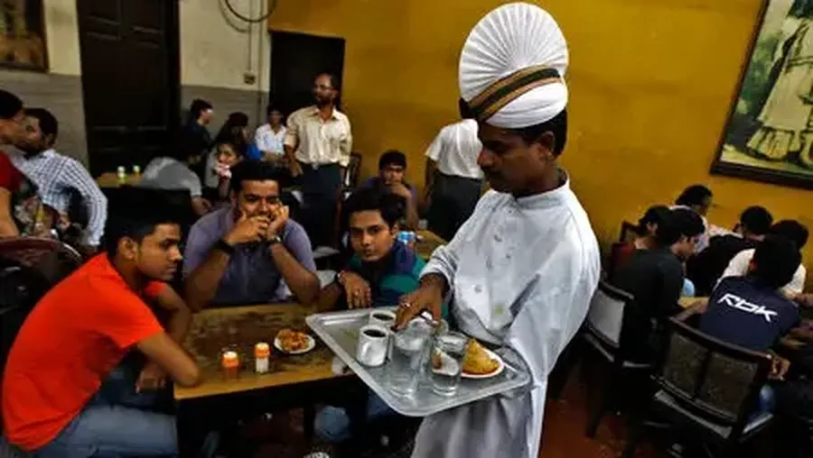 Seorang pelayan menyajikan kopi kepada pelanggan di dalam kedai kopi India di Kolkata. (REUTERS/Rupak De Chowdhuri/Files Reuters)