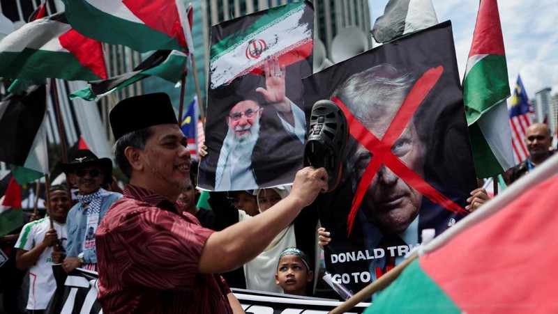 Para pendukung pro-Palestina mengibarkan bendera Palestina dan membawa replika Masjid Al-Aqsa selama unjuk rasa ke Kedutaan Besar AS untuk memperingati Hari al-Quds (Yerusalem), yang diprakarsai oleh Ruhollah Khomeini, pemimpin Revolusi Islam Iran tahun 1979 dan diperingati pada Jumat terakhir bulan puasa Ramadhan untuk menunjukkan solidaritas dengan Palestina dan penentangan terhadap Zionisme, di Kuala Lumpur, Malaysia, Jumat (13/3/2026). (REUTERS/Hasnoor Hussain)