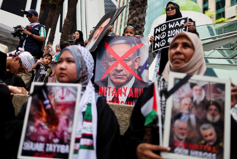Para pendukung pro-Palestina mengibarkan bendera Palestina dan membawa replika Masjid Al-Aqsa selama unjuk rasa ke Kedutaan Besar AS untuk memperingati Hari al-Quds (Yerusalem), yang diprakarsai oleh Ruhollah Khomeini, pemimpin Revolusi Islam Iran tahun 1979 dan diperingati pada Jumat terakhir bulan puasa Ramadhan untuk menunjukkan solidaritas dengan Palestina dan penentangan terhadap Zionisme, di Kuala Lumpur, Malaysia, Jumat (13/3/2026). (REUTERS/Hasnoor Hussain)