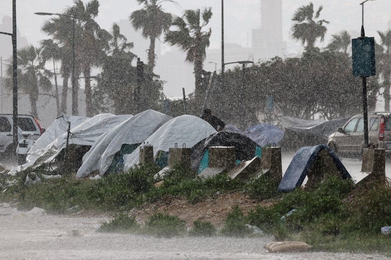Rain falls over tents used by displaced people on a street along the corniche overlooking the sea, following an escalation between Hezbollah and Israel, amid the U.S.-Israeli conflict with Iran, in Beirut, Lebanon, March 15, 2026. REUTERS/Amr Abdallah Dalsh