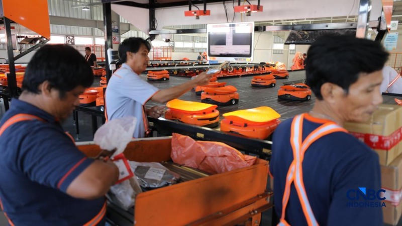 ekerja mengawasi robot sortir otomatis yang beroperasi di Sentral Pengolahan Pos (SPP), Jakarta, Senin, (16/3/2026). (CNBC Indonesia/Tri Susilo)