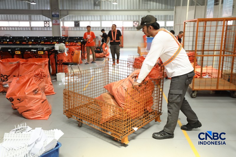 ekerja mengawasi robot sortir otomatis yang beroperasi di Sentral Pengolahan Pos (SPP), Jakarta, Senin, (16/3/2026). (CNBC Indonesia/Tri Susilo)