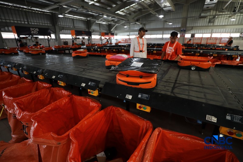 ekerja mengawasi robot sortir otomatis yang beroperasi di Sentral Pengolahan Pos (SPP), Jakarta, Senin, (16/3/2026). (CNBC Indonesia/Tri Susilo)