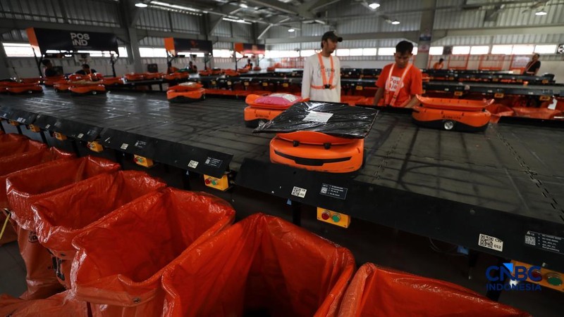 ekerja mengawasi robot sortir otomatis yang beroperasi di Sentral Pengolahan Pos (SPP), Jakarta, Senin, (16/3/2026). (CNBC Indonesia/Tri Susilo)