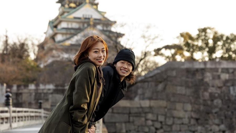 Ilustrasi pasangan berlibur di depan kastil Osaka, Jepang. (Dok. Freepik)