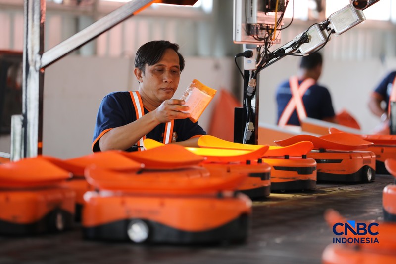 ekerja mengawasi robot sortir otomatis yang beroperasi di Sentral Pengolahan Pos (SPP), Jakarta, Senin, (16/3/2026). (CNBC Indonesia/Tri Susilo)