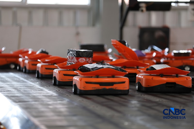 ekerja mengawasi robot sortir otomatis yang beroperasi di Sentral Pengolahan Pos (SPP), Jakarta, Senin, (16/3/2026). (CNBC Indonesia/Tri Susilo)