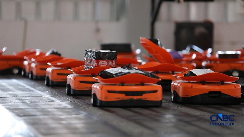 ekerja mengawasi robot sortir otomatis yang beroperasi di Sentral Pengolahan Pos (SPP), Jakarta, Senin, (16/3/2026). (CNBC Indonesia/Tri Susilo)