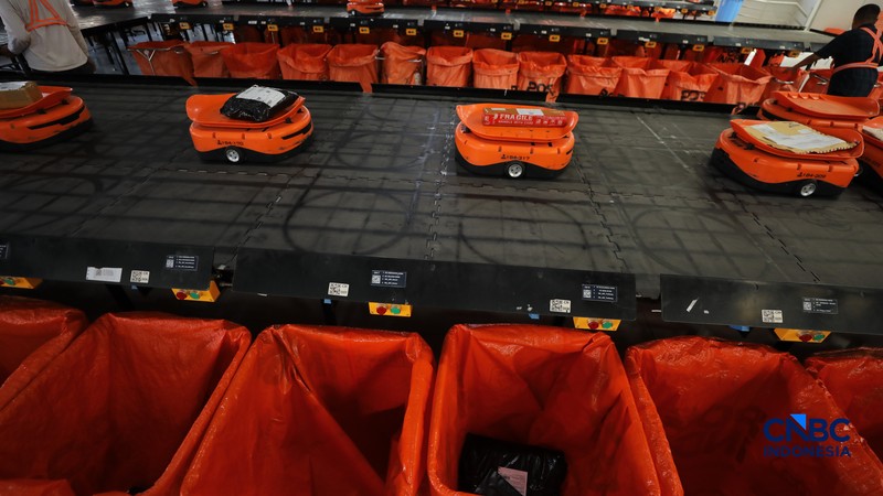 ekerja mengawasi robot sortir otomatis yang beroperasi di Sentral Pengolahan Pos (SPP), Jakarta, Senin, (16/3/2026). (CNBC Indonesia/Tri Susilo)