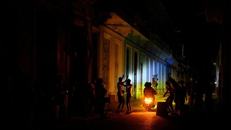 Orang-orang berkumpul di jalan saat terjadi pemadaman listrik ketika jaringan listrik nasional Kuba runtuh, menurut operator jaringan listrik negara itu, menyebabkan sekitar 10 juta orang tanpa aliran listrik di tengah blokade minyak yang diberlakukan AS, di Havana, Kuba, 16 Maret 2026. (REUTERS/Norlys Perez)