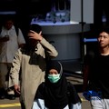 Warga berjalan dengan menutup kepala untuk berlindung dari terik matahari di kawasan Dukuh Atas, Jakarta, Selasa (17/3/2026). (CNBC Indonesia/Muhammad Sabki)