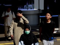Warga berjalan dengan menutup kepala untuk berlindung dari terik matahari di kawasan Dukuh Atas, Jakarta, Selasa (17/3/2026). (CNBC Indonesia/Muhammad Sabki)