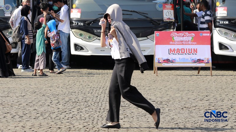 Warga berjalan dengan menutup kepala untuk berlindung dari terik matahari di kawasan Dukuh Atas, Jakarta, Selasa (17/3/2026). (CNBC Indonesia/Muhammad Sabki)