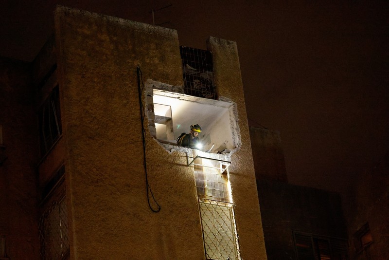 Bangunan yang rusak di lokasi dampak, setelah rentetan rudal yang diluncurkan dari Iran, di Tel Aviv, Israel, Kamis (19/3/2026) dini hari. (REUTERS/Amir Cohen)