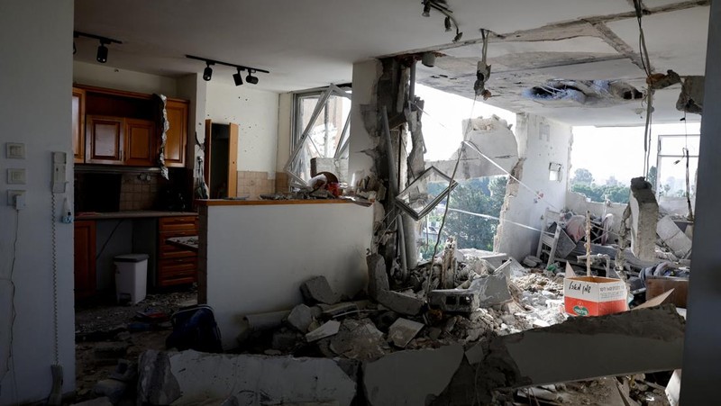 Bangunan yang rusak di lokasi dampak, setelah rentetan rudal yang diluncurkan dari Iran, di Tel Aviv, Israel, Kamis (19/3/2026) dini hari. (REUTERS/Amir Cohen)