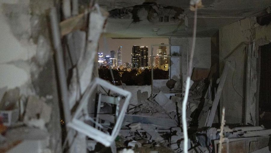 Bangunan yang rusak di lokasi dampak, setelah rentetan rudal yang diluncurkan dari Iran, di Tel Aviv, Israel, Kamis (19/3/2026) dini hari. (REUTERS/Amir Cohen)
