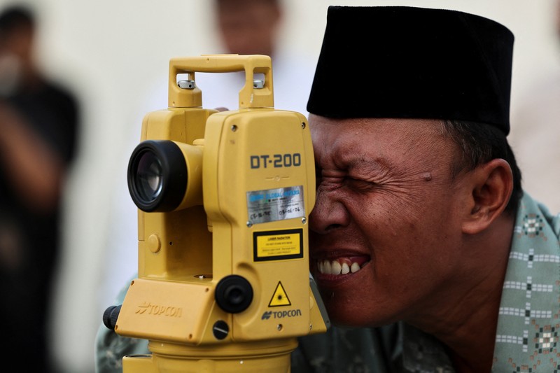Petugas mengamati posisi bulan menjelang Idul Fitri, yang menandai berakhirnya bulan suci puasa Ramadhan, di Jakarta, Kamis (19/3/2026). (REUTERS/Willy Kurniawan)