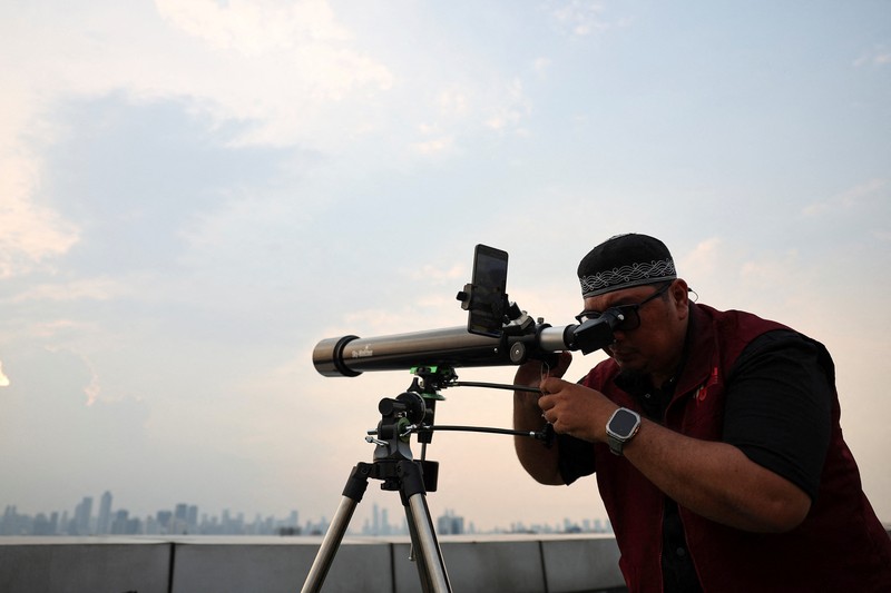 Petugas mengamati posisi bulan menjelang Idul Fitri, yang menandai berakhirnya bulan suci puasa Ramadhan, di Jakarta, Kamis (19/3/2026). (REUTERS/Willy Kurniawan)