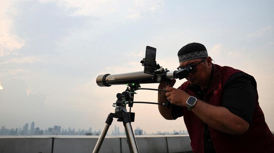 Petugas mengamati posisi bulan menjelang Idul Fitri, yang menandai berakhirnya bulan suci puasa Ramadhan, di Jakarta, Kamis (19/3/2026). (REUTERS/Willy Kurniawan)